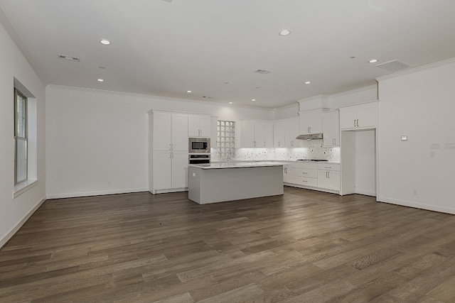 kitchen with white cabinets, dark hardwood / wood-style floors, a kitchen island, and stainless steel appliances