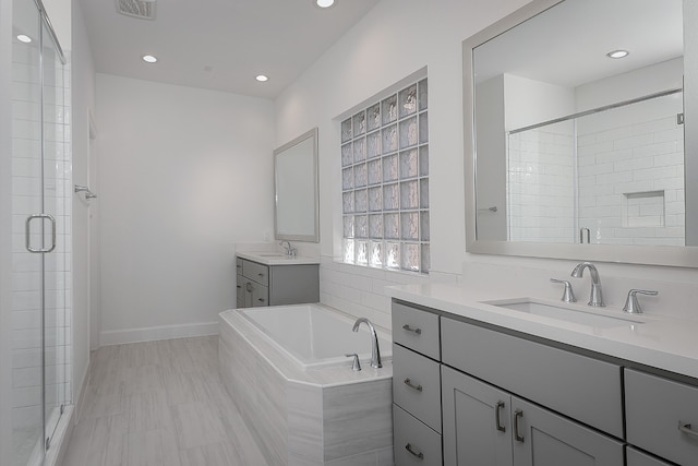 bathroom with vanity and separate shower and tub