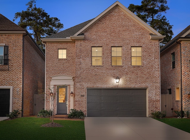 view of front property featuring a lawn and a garage