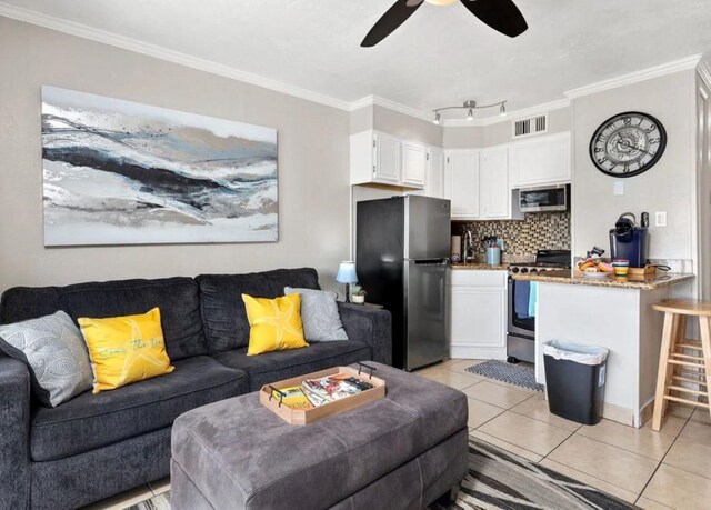 6102 Seawall Blvd Unit 318, Galveston, TX 77551 - living room with visible vents, a ceiling fan, crown molding, and light tile patterned flooring