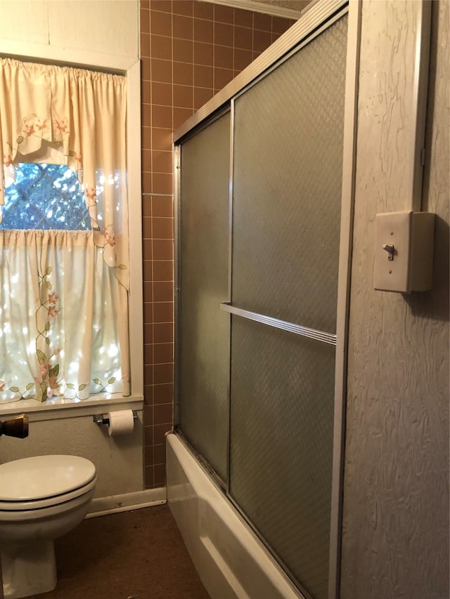 bathroom with enclosed tub / shower combo and toilet