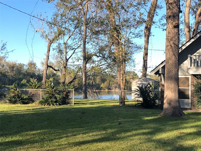 view of yard with a water view and a storage shed