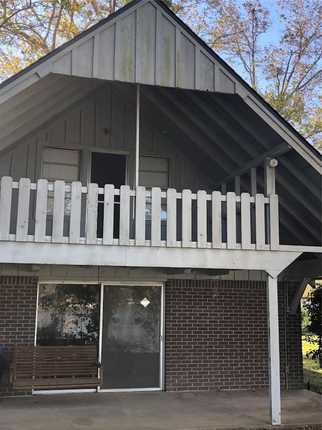 1544 E Taylor Lake Cir, Livingston, TX 77351 - view of side of home with brick siding, a balcony, and board and batten siding