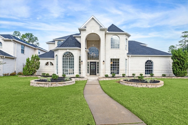 french country inspired facade featuring a front yard