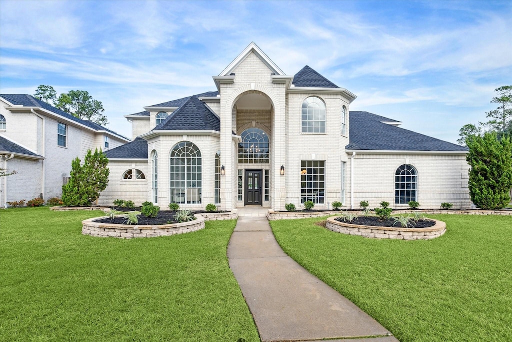 17624 Shadow Valley Dr, Spring, TX 77379 - french provincial home with brick siding, a shingled roof, and a front lawn