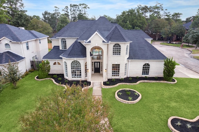 french country inspired facade with a front yard