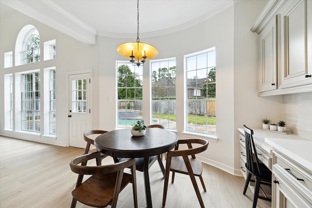 dining area with plenty of natural light, light hardwood / wood-style floors, and an inviting chandelier