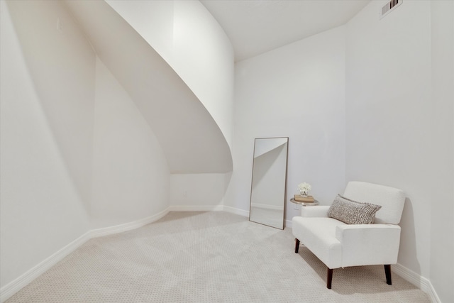 sitting room with light colored carpet and lofted ceiling