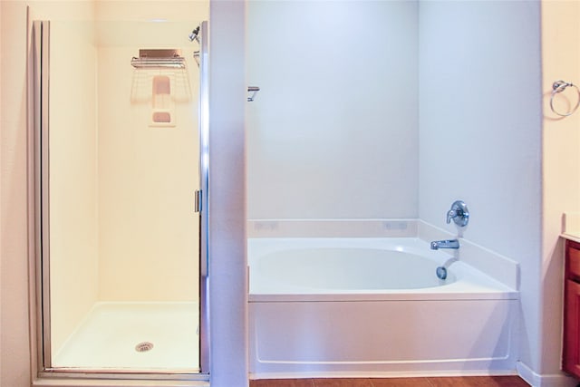 full bathroom featuring a shower stall, a bath, and vanity