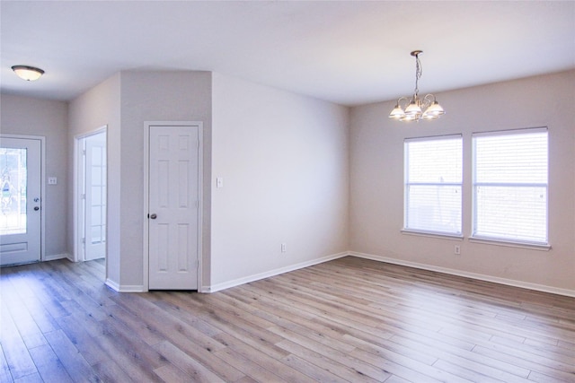 interior space featuring a notable chandelier, baseboards, and wood finished floors