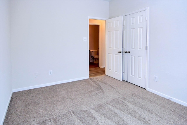 unfurnished bedroom featuring a closet, carpet, and baseboards