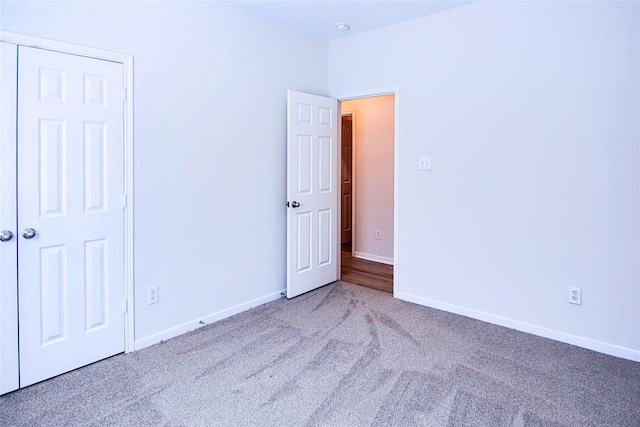 unfurnished bedroom with carpet flooring and baseboards