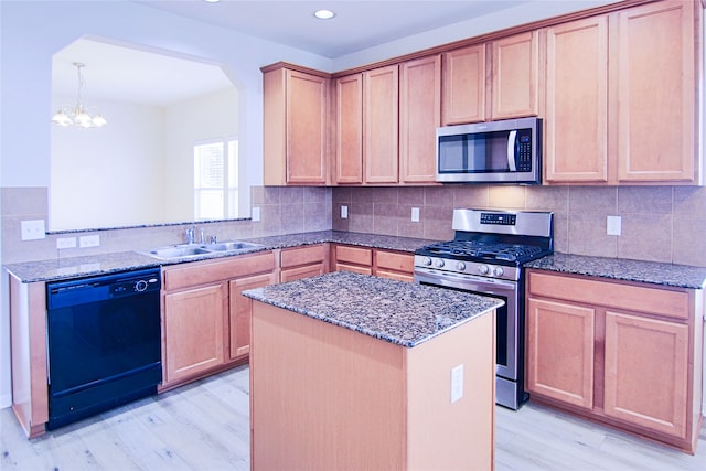 kitchen with dark stone counters, stainless steel appliances, and a sink