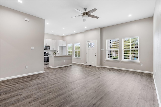1319 E 35th St, Houston, TX 77022 - unfurnished living room featuring dark wood-style floors, a sink, ceiling fan, baseboards, and recessed lighting