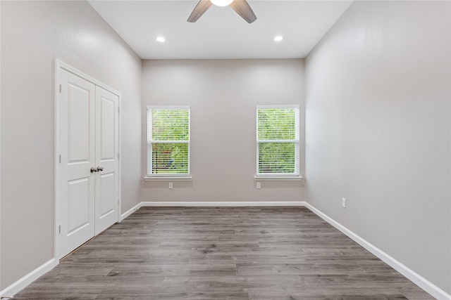 spare room with recessed lighting, wood finished floors, a ceiling fan, and baseboards