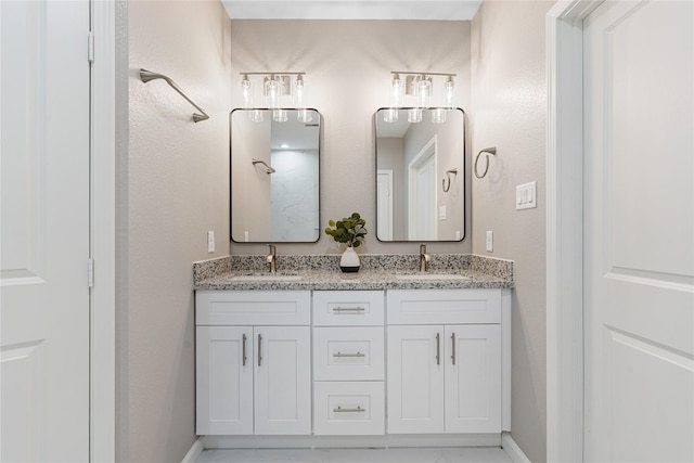 full bathroom featuring double vanity, a sink, and baseboards