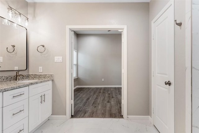 bathroom with marble finish floor, baseboards, and vanity