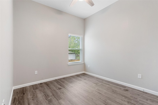 empty room with ceiling fan, baseboards, and wood finished floors