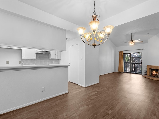 interior space with dark hardwood / wood-style floors, ceiling fan with notable chandelier, and vaulted ceiling