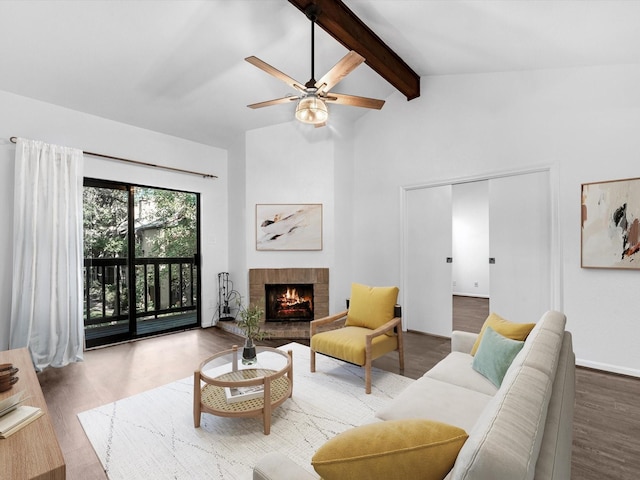 living area featuring high vaulted ceiling, a brick fireplace, wood finished floors, and beam ceiling