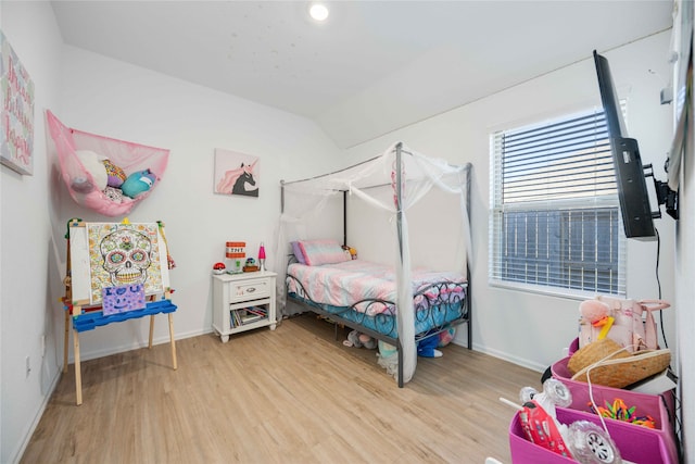 bedroom with hardwood / wood-style floors and vaulted ceiling