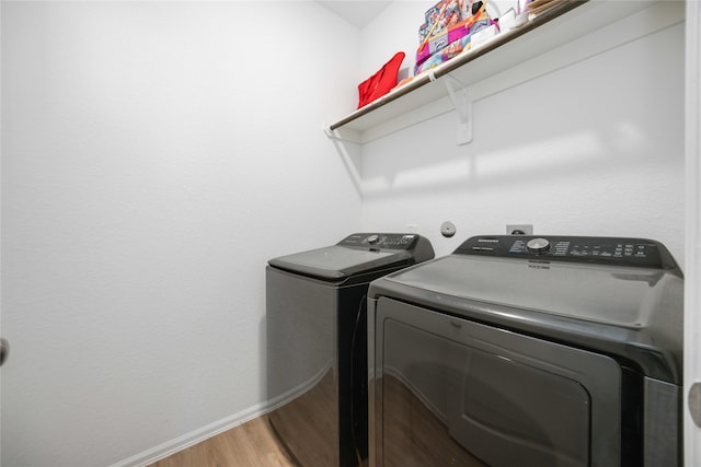 laundry room featuring hardwood / wood-style flooring and separate washer and dryer