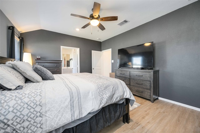 bedroom featuring ceiling fan, ensuite bathroom, light hardwood / wood-style floors, and lofted ceiling