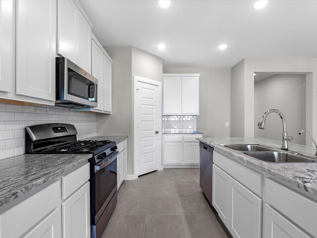 kitchen featuring backsplash, white cabinetry, sink, and stainless steel appliances