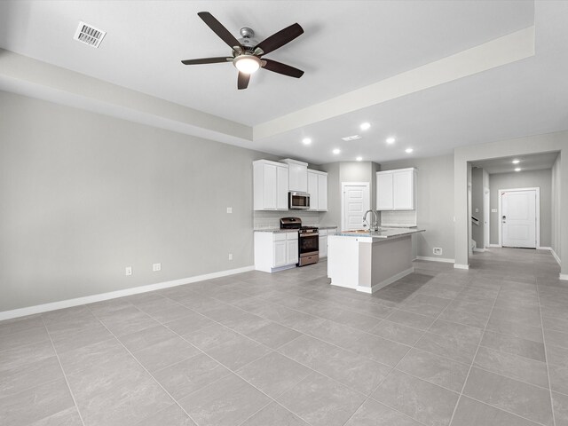 kitchen with white cabinetry, ceiling fan, a kitchen island with sink, light tile patterned flooring, and appliances with stainless steel finishes