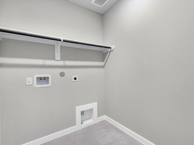 laundry area featuring hookup for an electric dryer, light tile patterned flooring, gas dryer hookup, and washer hookup