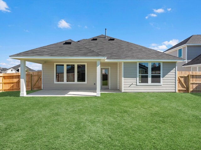 rear view of property with a yard and a patio