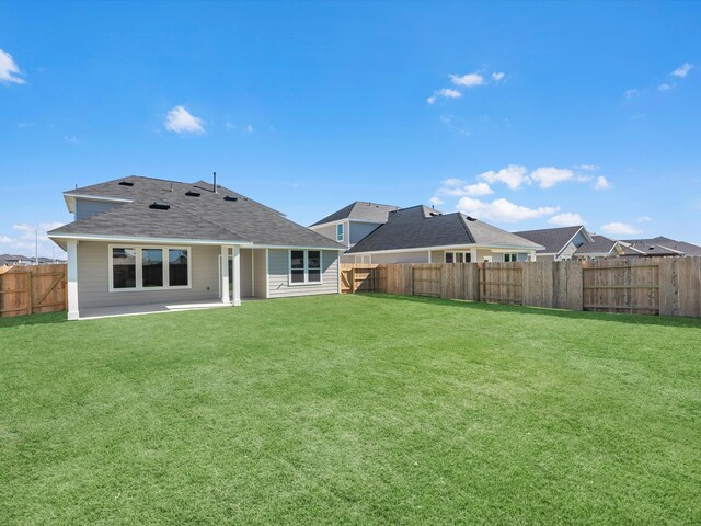 back of property with a lawn and a patio