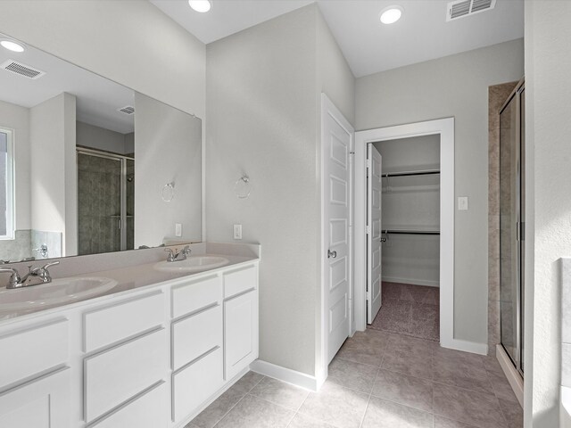 bathroom with vanity, tile patterned floors, and a shower with door