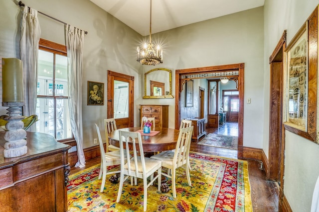 dining room with dark wood-type flooring and a notable chandelier