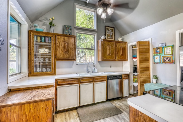 kitchen with dishwasher, sink, vaulted ceiling, ceiling fan, and light wood-type flooring