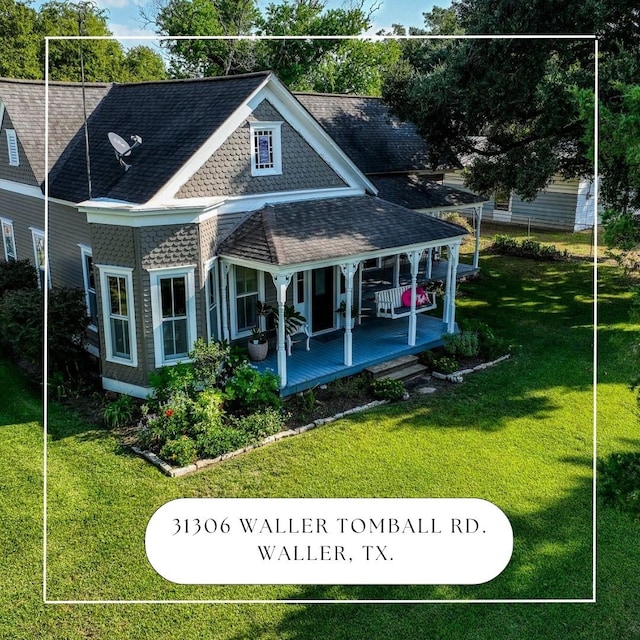 rear view of property with covered porch and a yard