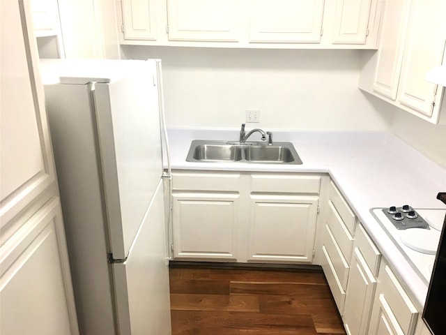 kitchen with white cabinets, sink, and white fridge