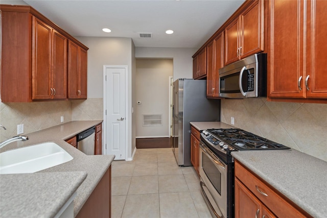 kitchen with decorative backsplash, sink, light tile patterned flooring, and appliances with stainless steel finishes