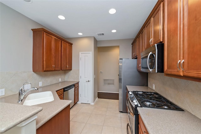 kitchen with light tile patterned flooring, appliances with stainless steel finishes, backsplash, and sink