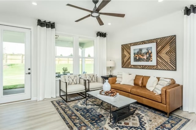 living room with ceiling fan and light wood-type flooring