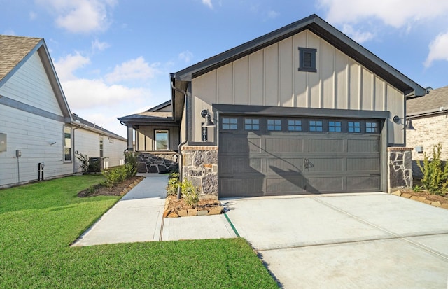 view of front of property with board and batten siding, a garage, driveway, and a front lawn