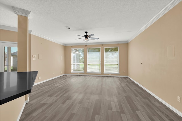 unfurnished living room with dark hardwood / wood-style floors, crown molding, ceiling fan, and a healthy amount of sunlight