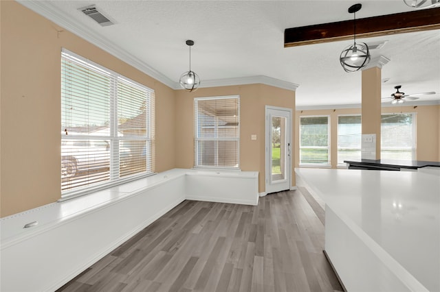 unfurnished dining area featuring crown molding, light hardwood / wood-style flooring, ceiling fan, and a textured ceiling