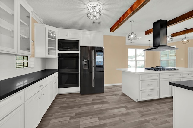 kitchen with black appliances, hanging light fixtures, beam ceiling, island range hood, and white cabinetry