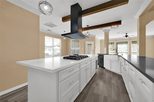 kitchen with island range hood, dark hardwood / wood-style flooring, a healthy amount of sunlight, and stainless steel gas cooktop