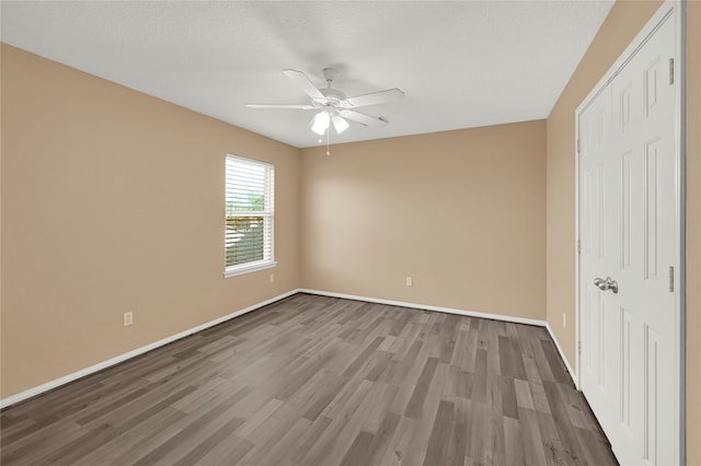 unfurnished bedroom with ceiling fan, dark wood-type flooring, and a textured ceiling