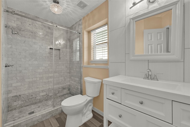 bathroom with hardwood / wood-style floors, vanity, a shower with door, and toilet