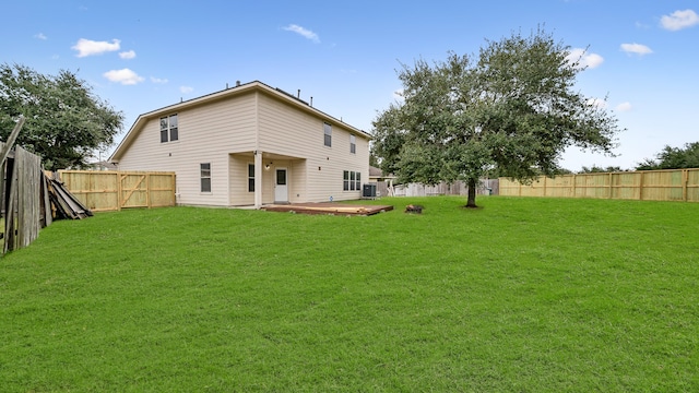 back of property featuring central AC unit, a yard, and a wooden deck