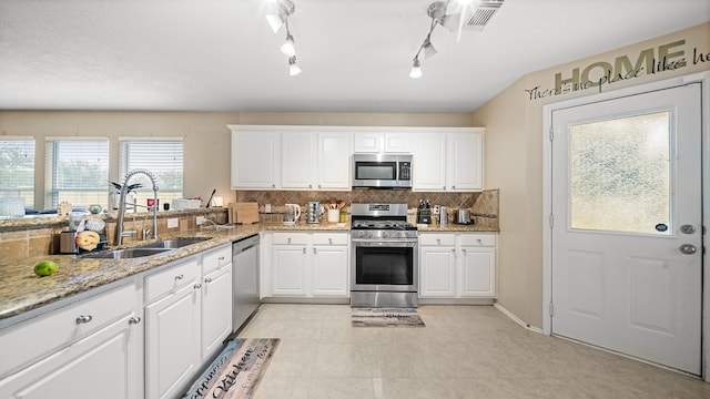 kitchen featuring white cabinets, rail lighting, stainless steel appliances, and sink