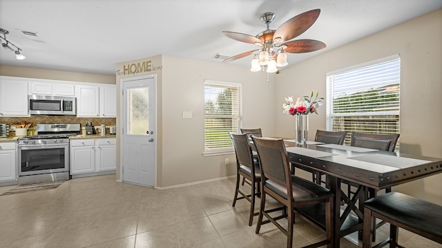 dining area featuring ceiling fan, light tile patterned floors, and a wealth of natural light